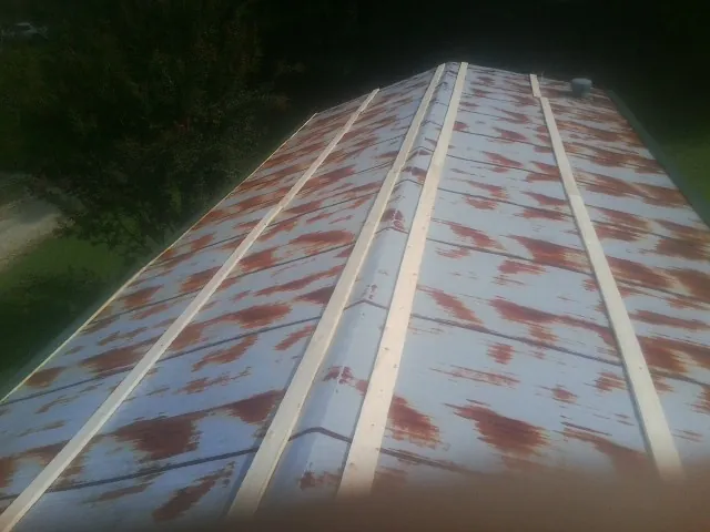 Rusted metal roof panels with new wood purlins before replacement — Storm Damage Roof Repair in Diamondhead by Roofing Brothers