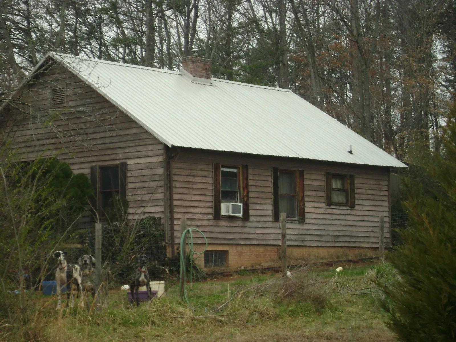 White metal roof on an old wood sided farmhouse, from a Metal Roof Installation job in Diamondhead